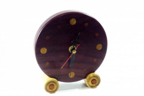 Approximately 136mm in diameter. A fine piece of craftsmanship a handmade cheeky wooden clock for the desk, mantle or shelf. This is the real colour of the wood and has not been altered in any way, it will enrich with age. The clock hands are of course RoHS approved and tested and come complete with full instructions. Designed and made by me in Shropshire - not mass produced; each of my Tommy Woodpecker Woodworks clocks is slightly different and unique, beautifully and lovingly finished with beeswax polish so the natural colour of the wood can speak for itself! An ideal gift for anyone who loves the unique richness and quality of the grain and colours of natural finely crafted wooden items. A special, memorable gift for a wedding, anniversary, housewarming, leaving or retirement gift for someone very special. All clocks are carefully packaged to ensure they reach you safely and have labels and care instructions, ideal for any gift. 1 x AA Battery operated, battery included for UK only not included for overseas, batteries cannot be airmailed. Care Instructions To set the time, do not push the hands of the clock around, use the white dial on the back of the clock mechanism to alter the time. To dust the clock, avoid damaging the hands by gently dusting one half of the clock face at a time, when the hands are clear of the area, then repeat for the other half of the clock face when the hands are clear of that area. The battery can be taken out for cleaning to stop the clock at any time. Occasionally a slightly damp cloth can be used if necessary. The wood will benefit from a little gentle application of beeswax once a year and will reward you with a continued shine.